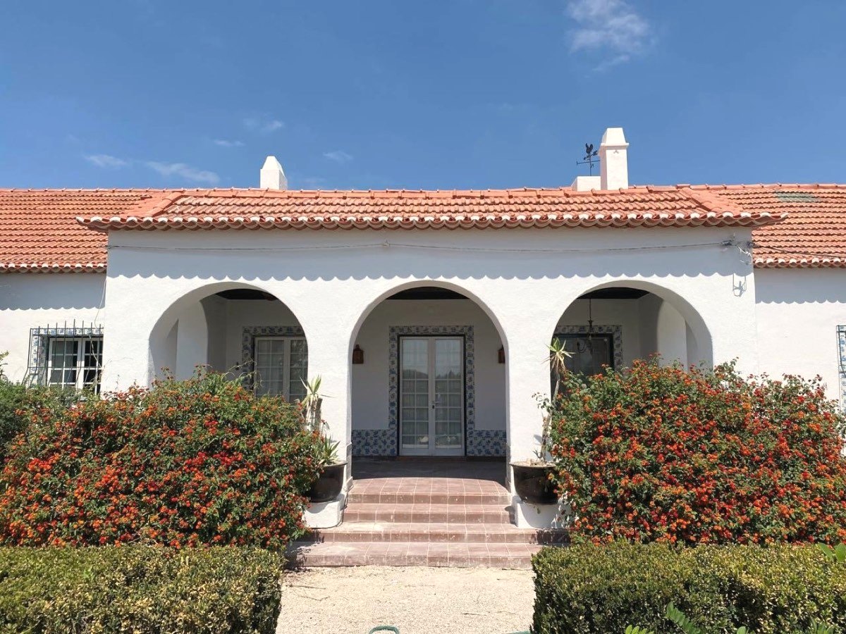 The white arched veranda of the Portuguese quinta under a blue sky