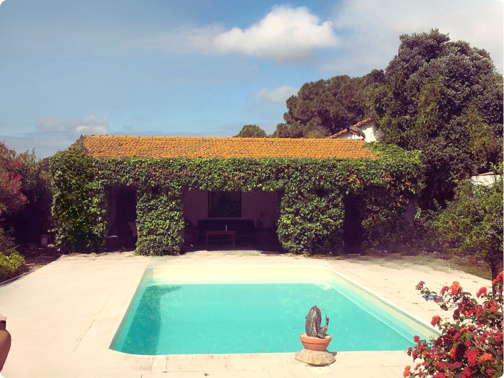 The ivy-covered pool house beside the swimming pool
