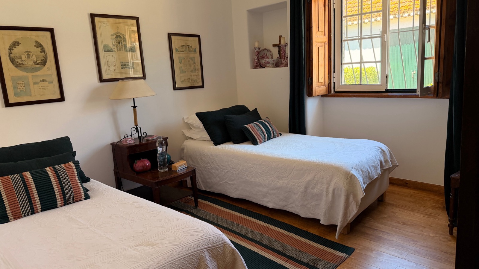 A twin bedroom with single beds and an open window