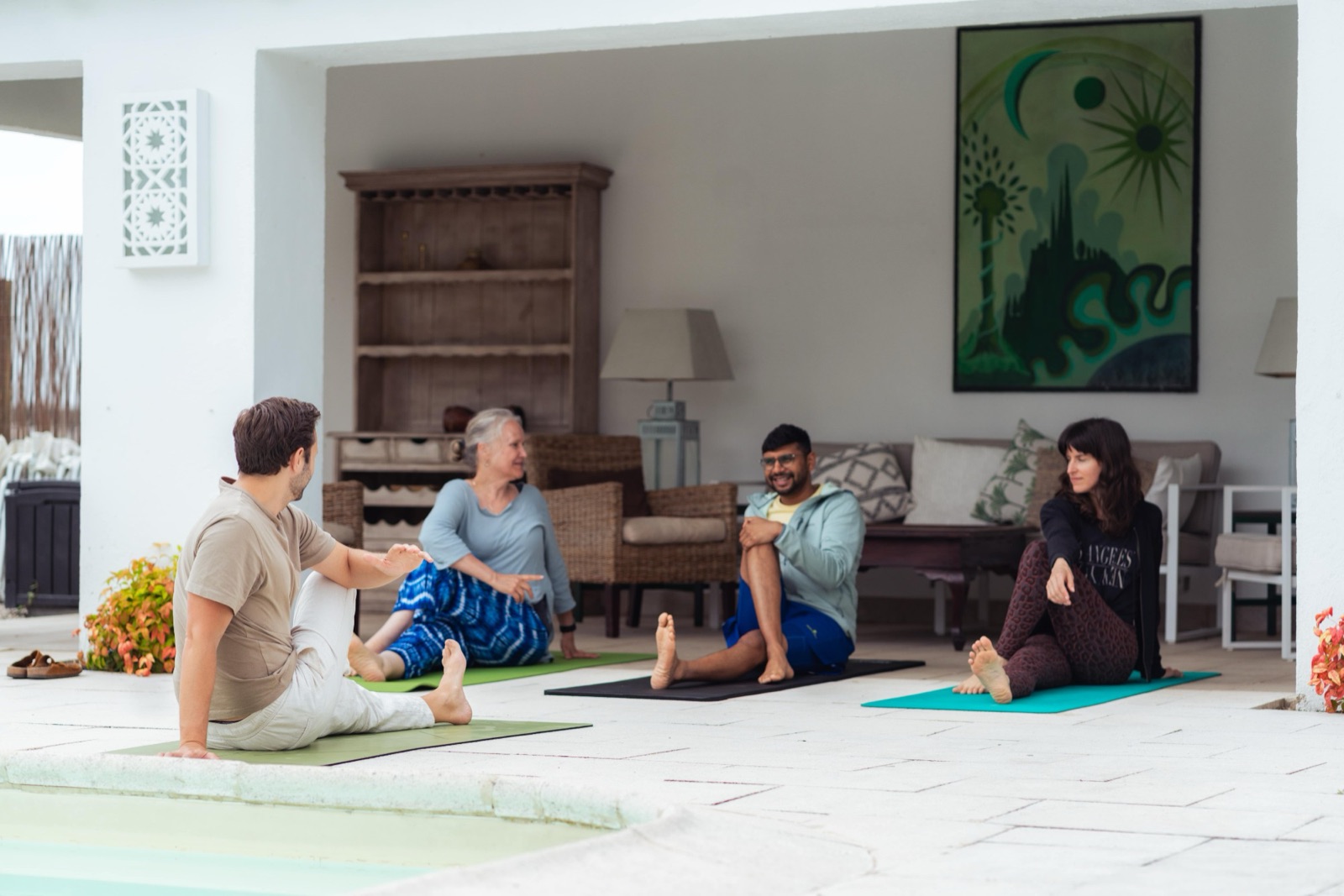 The group sitting together on mats for a check-in chat on the veranda