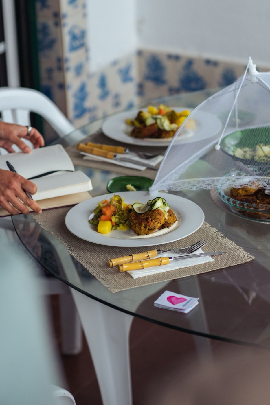 A plate of fresh vegan food beside a journal at the retreat table
