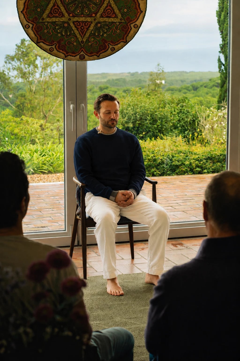 Sam meditating with a group, the sea in the distance